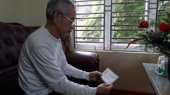 Cựu chiến binh Nguyễn Thế Điệp xúc động xem lại bức ảnh chân dung liệt sĩ Nguyễn Văn Uẩn.